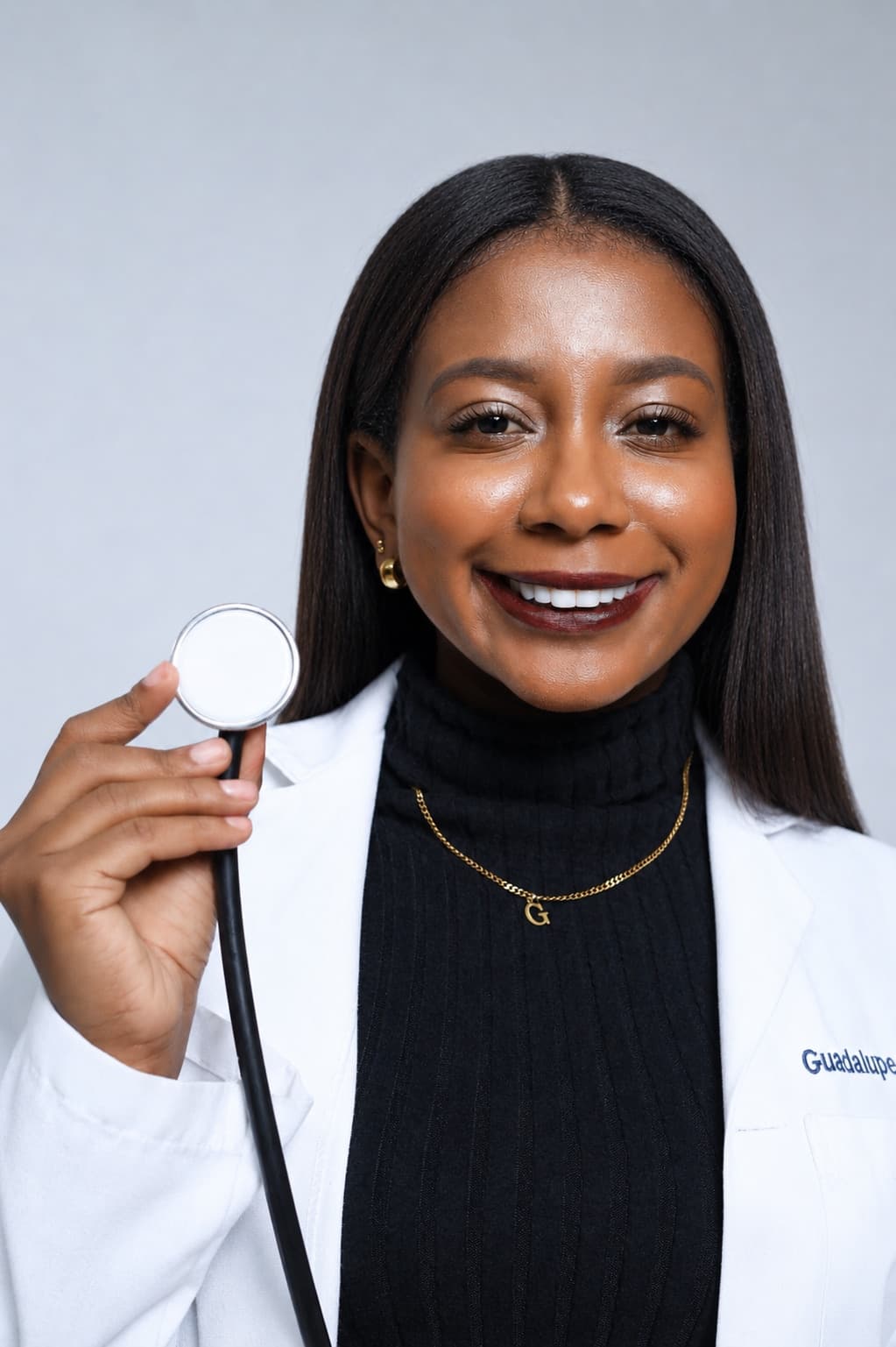 Guadalupe Guzmán, nutricionista clínica, sonriendo con bata blanca bordada y estetoscopio